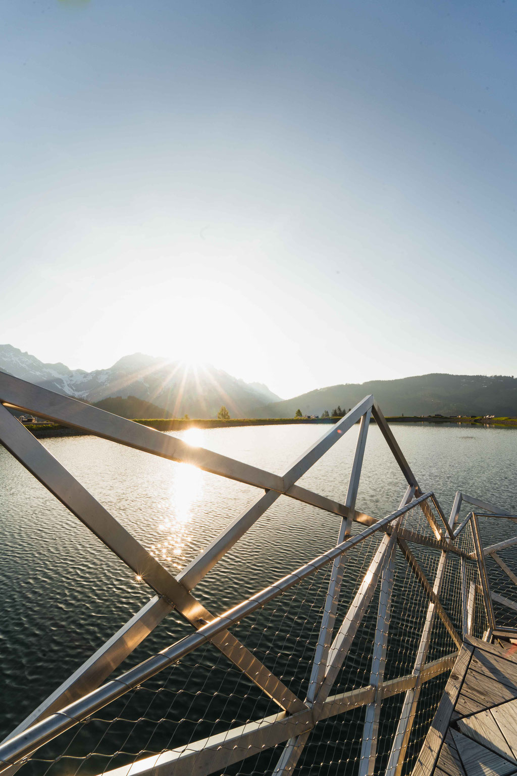 Sonnenaufgang am Prinzensee in Maria Alm mit Spiegelung der Berge im See und Aussichtsplattform – Familienwanderung am Hochkönig im Salzburger Land.