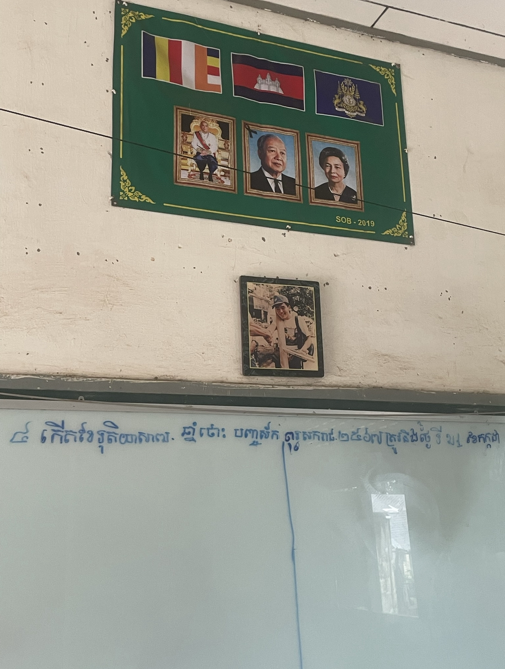 教室のホワイトボードの上に飾られている中田さんの写真