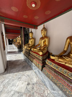Einer der zahlreichen Tempelgänge im Wat Poh voller goldener 3 m hohen Buddha-Figuren