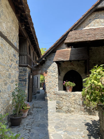 monastero in pietra con vasi di fiori e piante