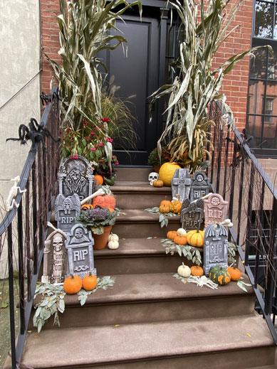 decorazione di Halloween su atrio di casa con lapidi e zucche su scalini