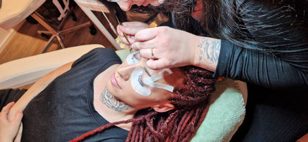 Lashstilystin bringt eine Wimpernverlängerung/Lashextensions an