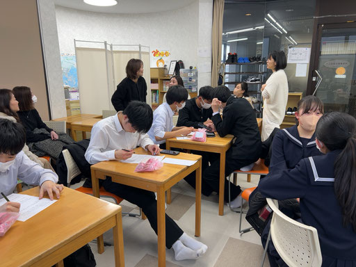 喜び会う講師と保護者(奥)合格体験記を書く生徒(左)語らう生徒(右)