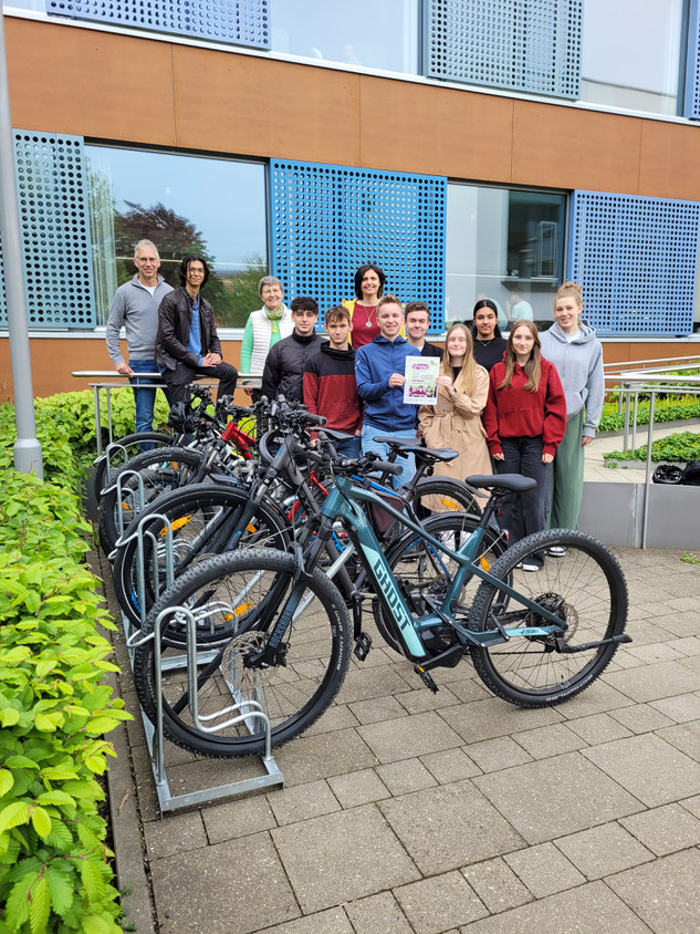 Das letztjährige P-Seminar Klimaschule unter der Leitung von Jürgen Horzella (ganz links) und Lena Pollak (hinten rechts) freut sich gemeinsam mit Schulleiterin Dr. Renate Rachidi (3. von links) über die neue Fahrradabstellanlage und die Urkunde.