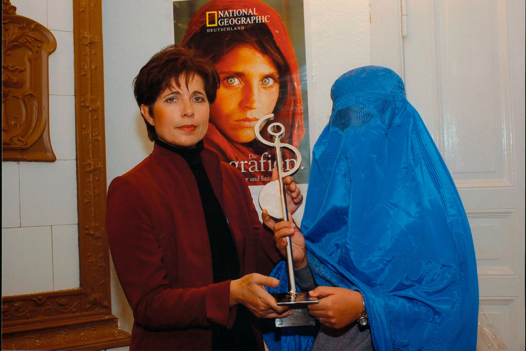 ZDF-TV host Conny Hermann hands over an abstract price sculpture by HEX to a representative of RAWA. Victoria Siddall is director of FRIEZE ART FAIR.