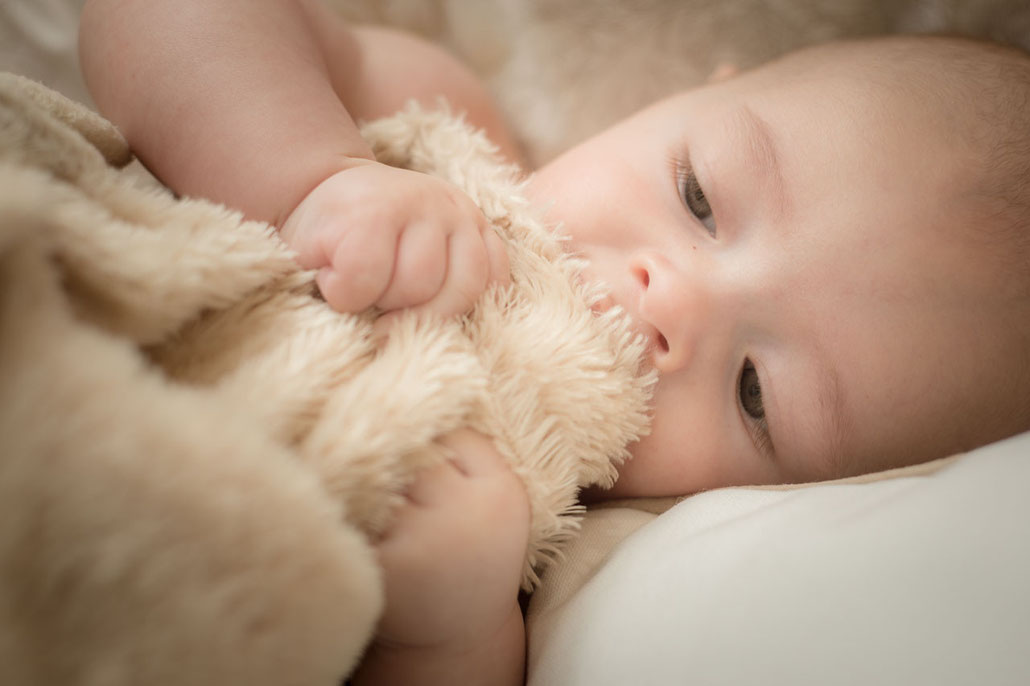  Se trata de una foto tomada por zunzu de un precioso recién nacido que se encuentra agarrando una manta.