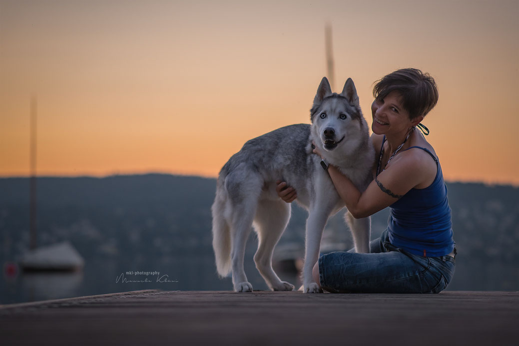 Husky und seine Besitzerin auf einem Steg am Zürichsee