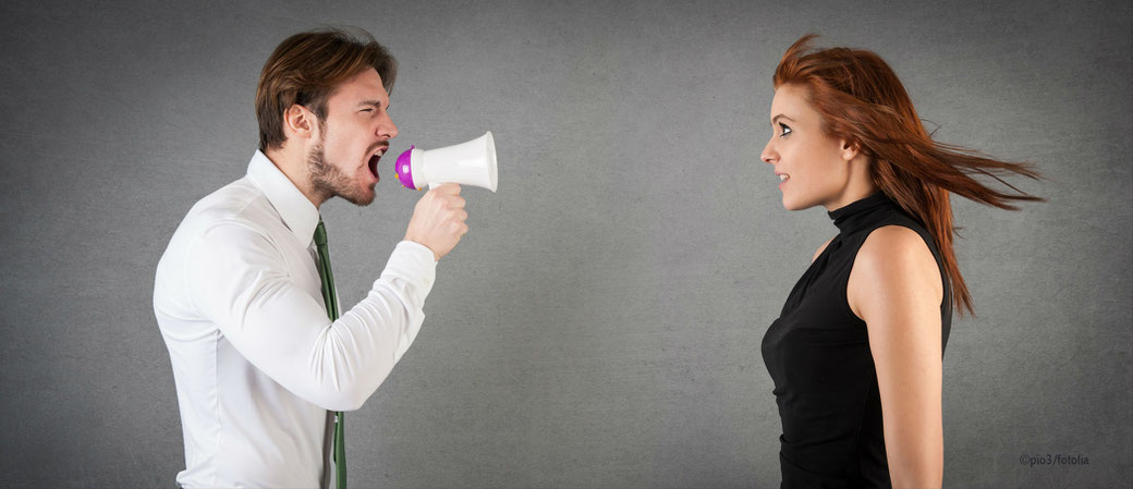 Mann schreit Frau mit Megaphone an
