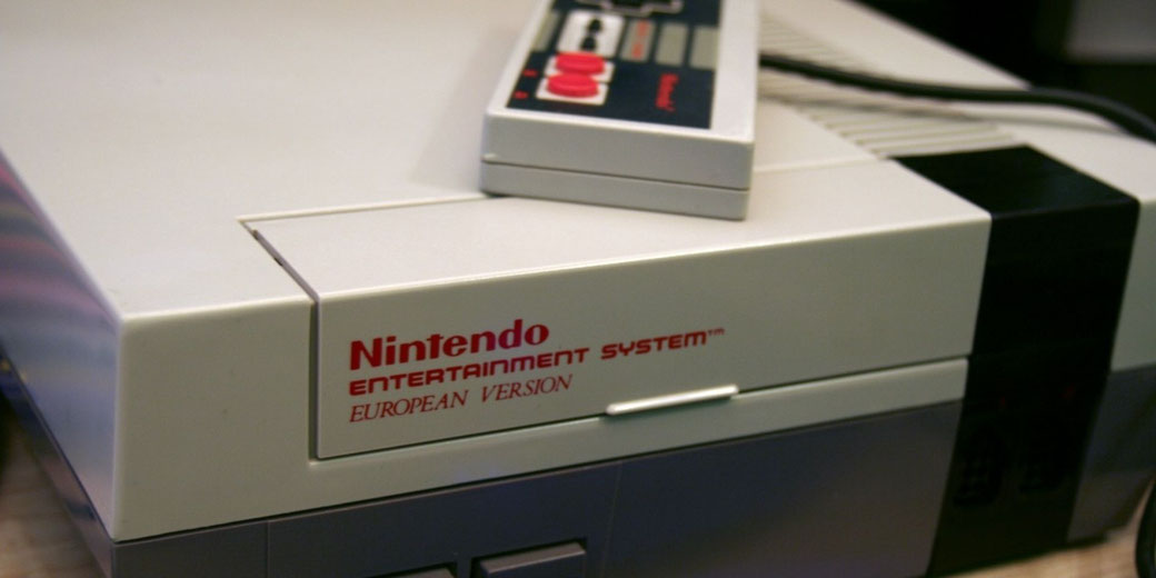 Close-up of a classic Nintendo Entertainment System console with controller on top, highlighting retro gaming hardware and nostalgic technology design.