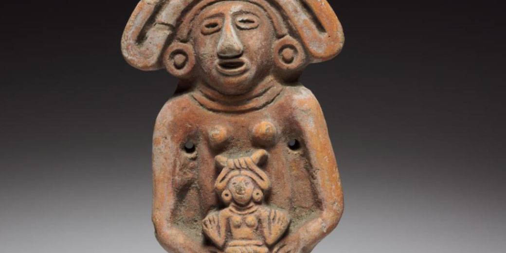 A terracotta figurine depicting a female figure with an elaborate headdress, holding a smaller figure. The artifact has a weathered surface and appears to be from an ancient Mesoamerican culture.