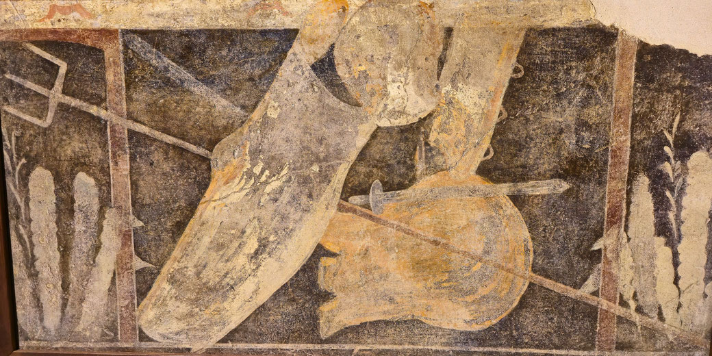 Faded Roman fresco fragment showing a gladiator items with a trident, large shield, and helmets in close combat amid dark background tones.