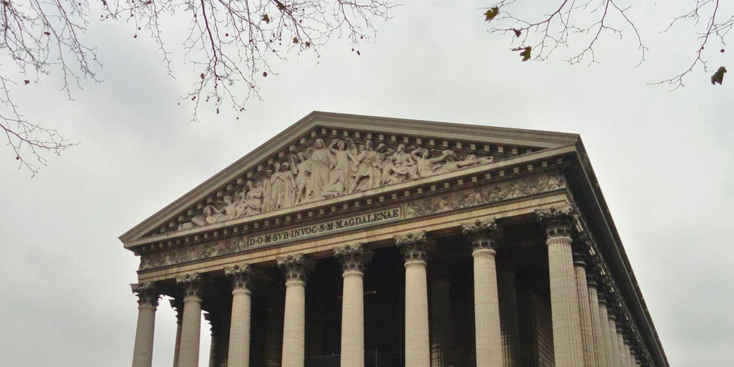 La Madeleine in Paris, a neoclassical church with a grand Corinthian-columned façade and a sculpted pediment, originally intended as a temple to Napoleon’s army.