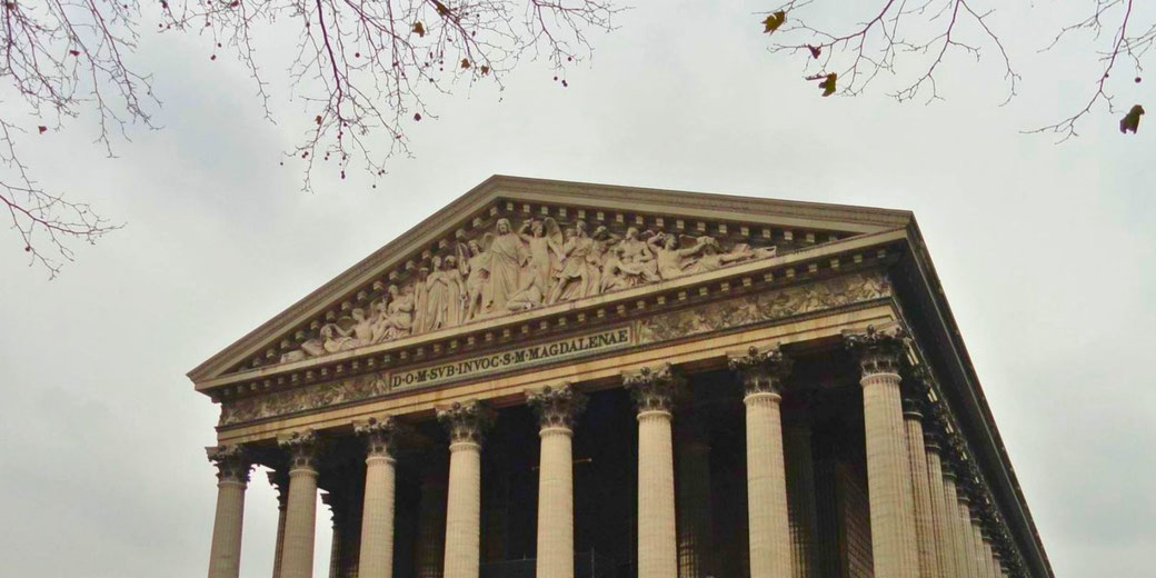 La Madeleine in Paris, a neoclassical church with a grand Corinthian-columned façade and a sculpted pediment, originally intended as a temple to Napoleon’s army.