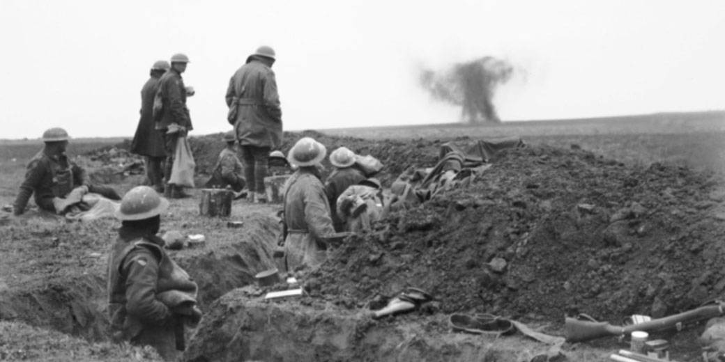 Soldiers stand in a trench observing an explosion in the distance during fighting near Lavieville, France, capturing a moment of tension on the Western Front.