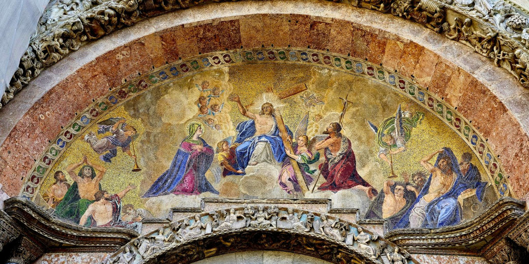 A mosaic on St. Mark’s Basilica in Venice, depicting Christ enthroned with a cross, surrounded by angels, Mary, John the Baptist, and figures reacting to judgment, set in a golden arch.