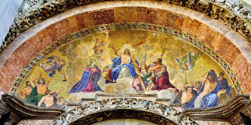 A mosaic on St. Mark’s Basilica in Venice, depicting Christ enthroned with a cross, surrounded by angels, Mary, John the Baptist, and figures reacting to judgment, set in a golden arch.