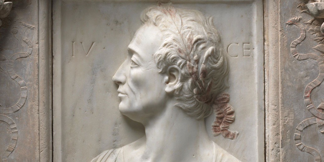 This Renaissance marble relief by Mino da Fiesole (and workshop) shows a side‑profile portrait of the Roman leader Julius Caesar, rendered with aged features and draped costume and set within a circular garland.