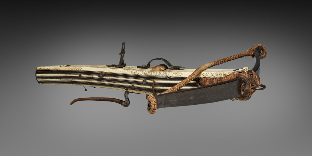 An intricately designed crossbow, featuring a wooden stock with alternating black and white stripes.