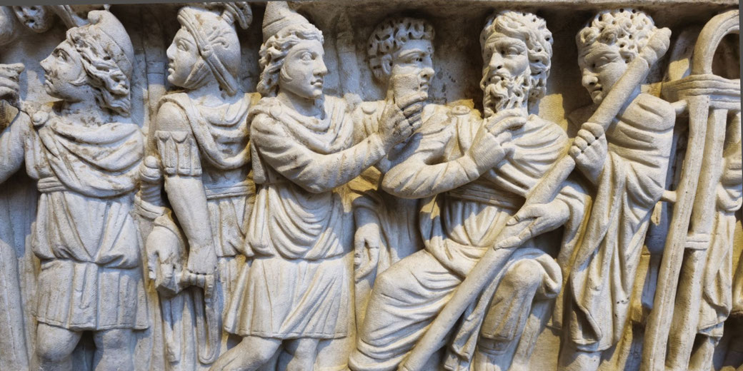 Ancient stone relief depicting Roman soldiers arresting a bearded man while others look on in dramatic poses.