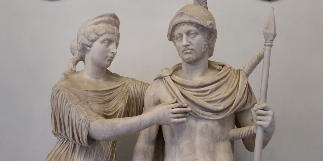 Marble statue of a woman gently touching a helmeted warrior's chest, with the warrior holding a spear and wearing a draped cloak.