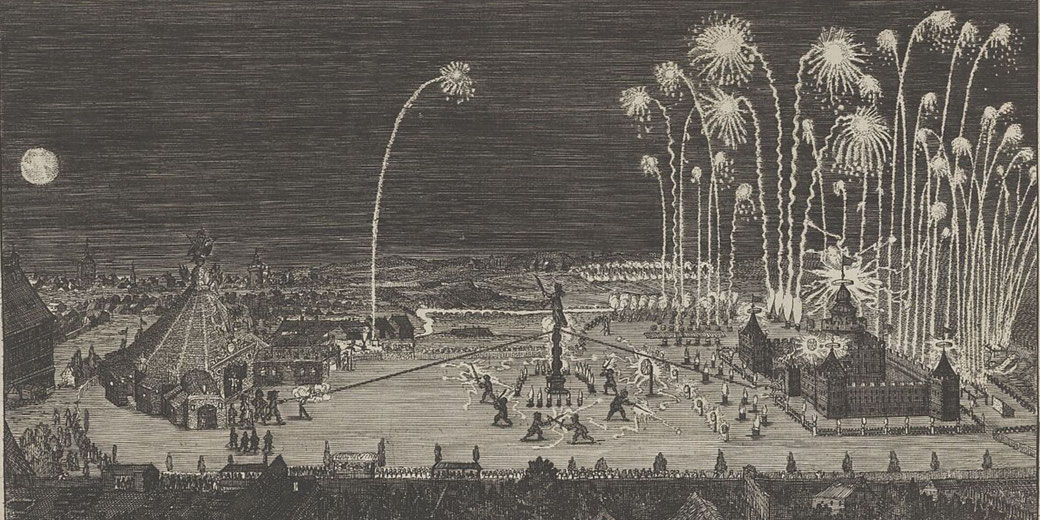 A grand nighttime fireworks display over a city square. People gather around structures, soldiers march, and rockets burst in the sky.