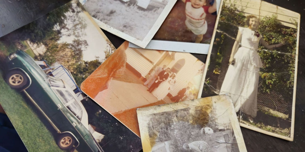 A collection of old, worn photographs featuring vintage cars, weddings, and people from past decades. The faded colors and creases suggest cherished memories preserved over time.