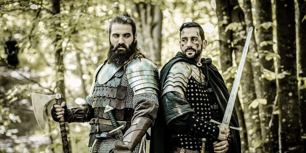 wo medieval warriors in armor, one wielding an axe and the other a sword.