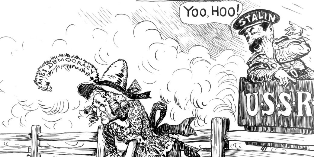 Elderly woman in headscarf leans on wooden fence amid smoke, while a caricatured man labeled Stalin shouts from a crate marked U.S.S.R., with “Miss Democracy” written above the woman.