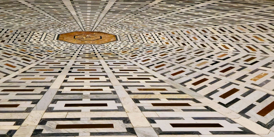 Geometric marble floor design with repeating rectangular patterns radiating from a central octagonal medallion.