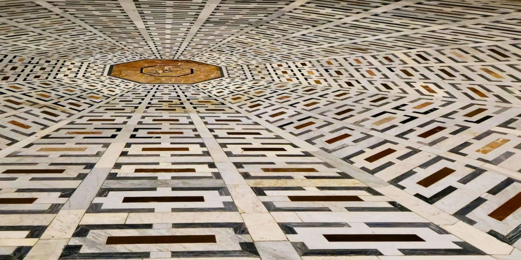 Geometric marble floor design with repeating rectangular patterns radiating from a central octagonal medallion.