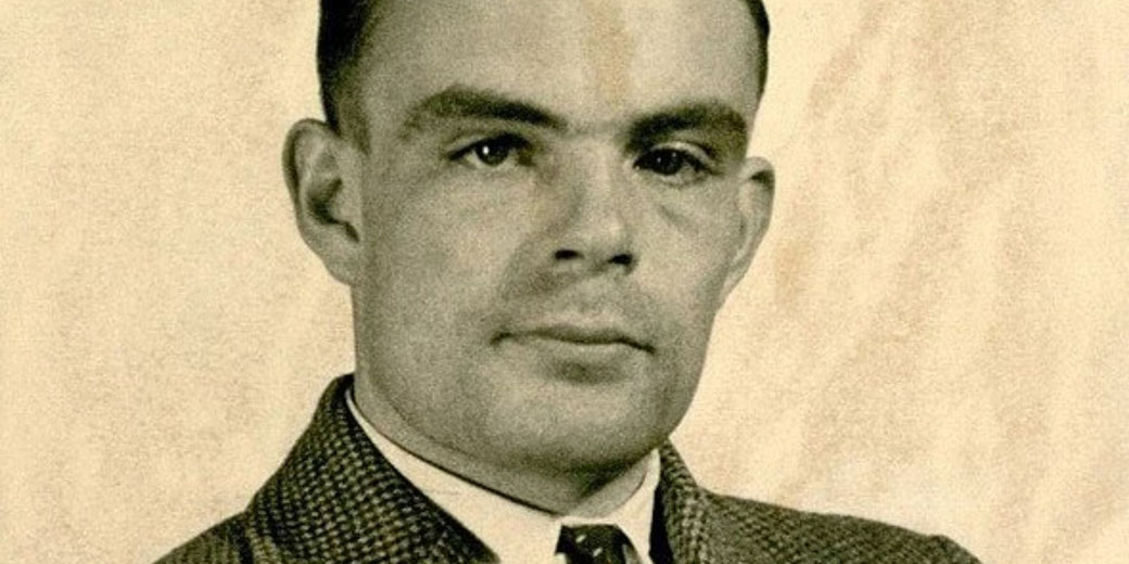 Vintage portrait of a man in a checkered suit and tie looking directly at the camera, set against a plain background.