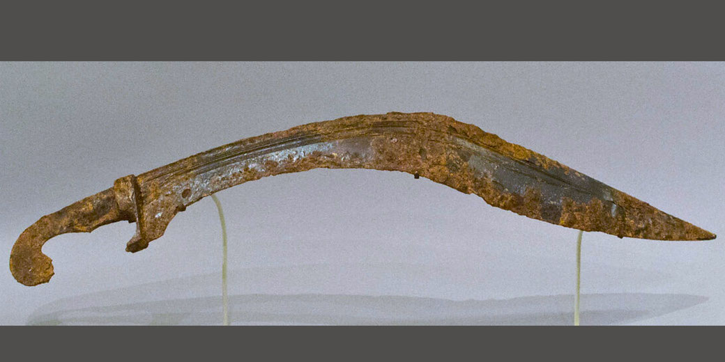 Curved Greek iron sword designed for delivering powerful downward strikes in battle.