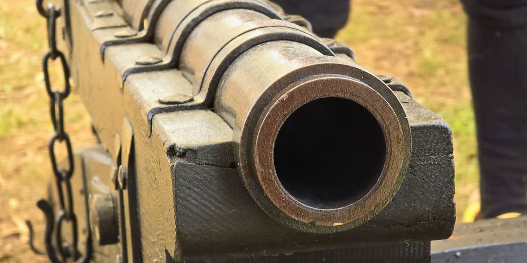 A close-up of a late medieval or early modern cannon. The metal barrel, reinforced with iron bands, suggests historical artillery used in warfare or reenactments.