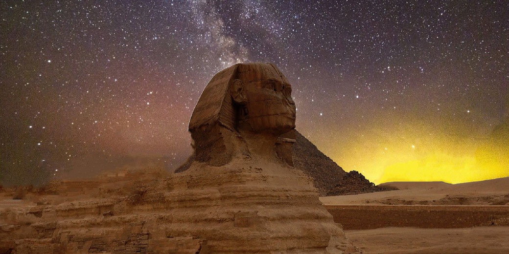 The Great Sphinx of Giza stands under a star-filled night sky with the Milky Way visible in the background.