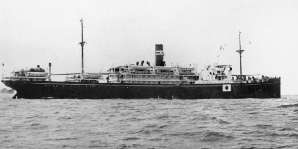 A Japanese hospital ship sails on open water, marked with a red cross symbol for medical purposes.