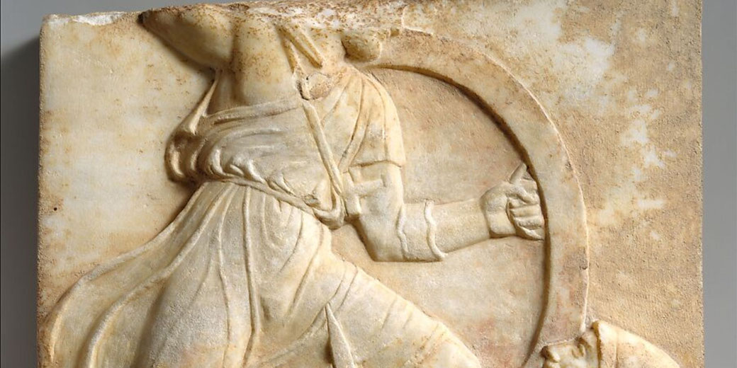 A marble relief depicting a hoplite in battle, wearing flowing attire and holding a shield, showcasing the artistry of ancient Greek grave steles commemorating warriors.