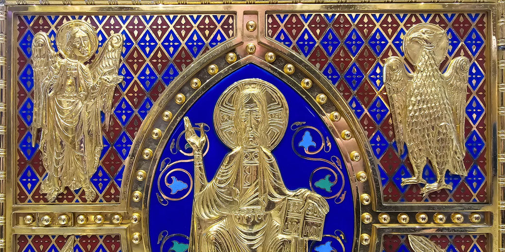 An ornate gold and enamel religious artwork depicting Christ, an angel, and an eagle, symbolizing the Evangelists. The intricate design reflects medieval Christian iconography.