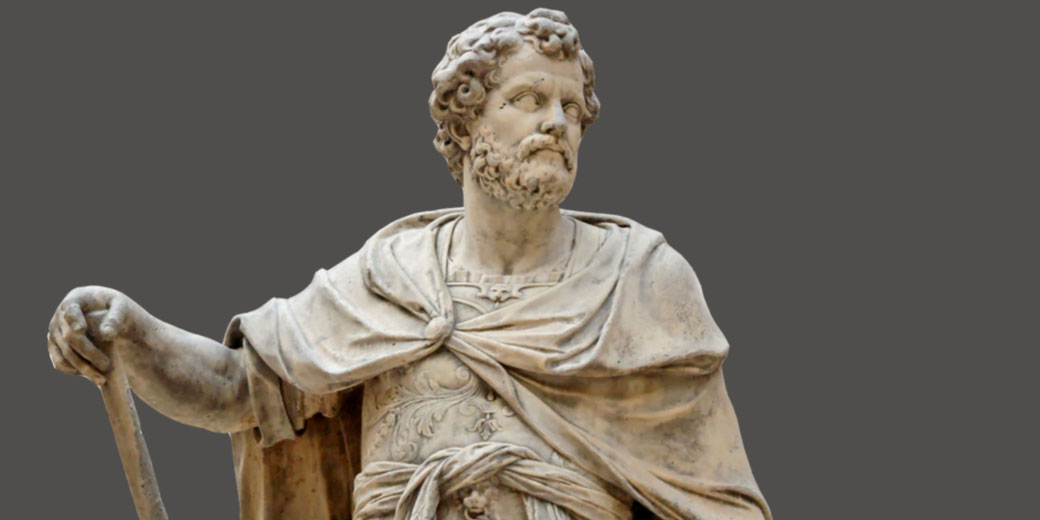 Marble statue of a bearded man in a Roman-style cloak and armor, holding a staff and gazing to the side.