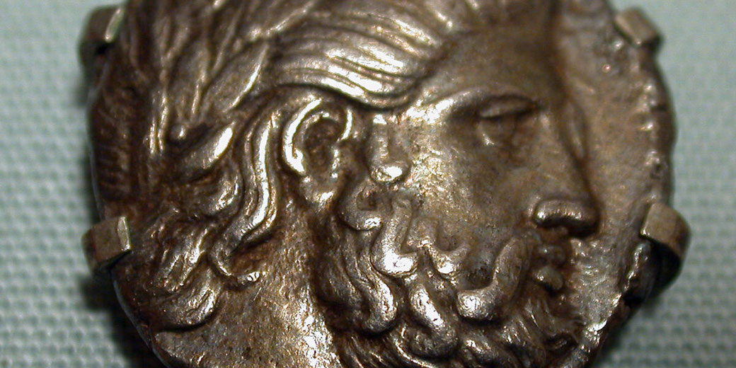 Ancient Greek silver coin featuring Zeus on one side and a horseman on the other, minted under Philip II of Macedon.