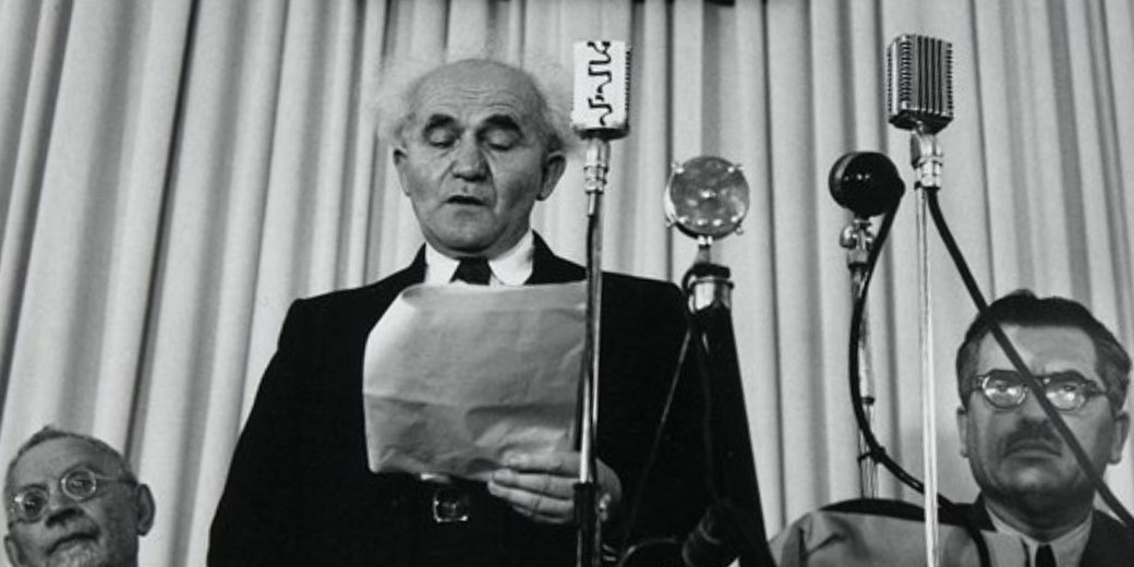 David Ben-Gurion reads Israel's Declaration of Independence beneath a portrait of Theodor Herzl at the Tel Aviv Museum.