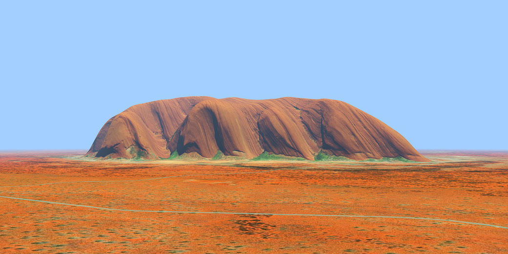 Uluru stands isolated in the red desert under a clear blue sky, surrounded by sparse vegetation and dry terrain.