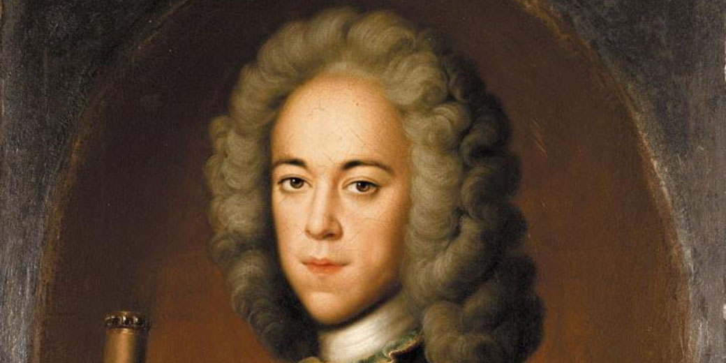 Portrait painting of a man with a pale face and powdered wig, dressed in formal attire, set against a dark background within an oval frame.