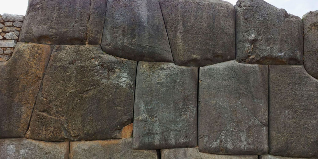 Incan masonry with massive, precisely cut stone blocks fitted seamlessly without mortar, demonstrating the advanced engineering skills of the Inca civilization.