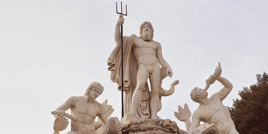 Marble fountain sculpture of Poseidon holding a trident, flanked by two muscular sea gods blowing conch shells, surrounded by sea creatures.