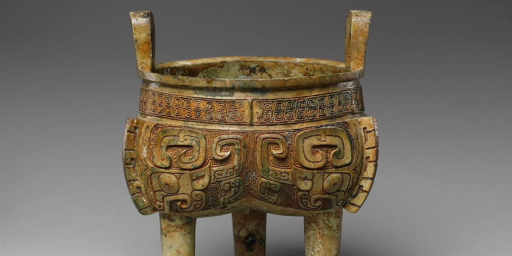 An ancient Chinese bronze tripod cauldron (Liding) with intricate geometric and zoomorphic patterns.