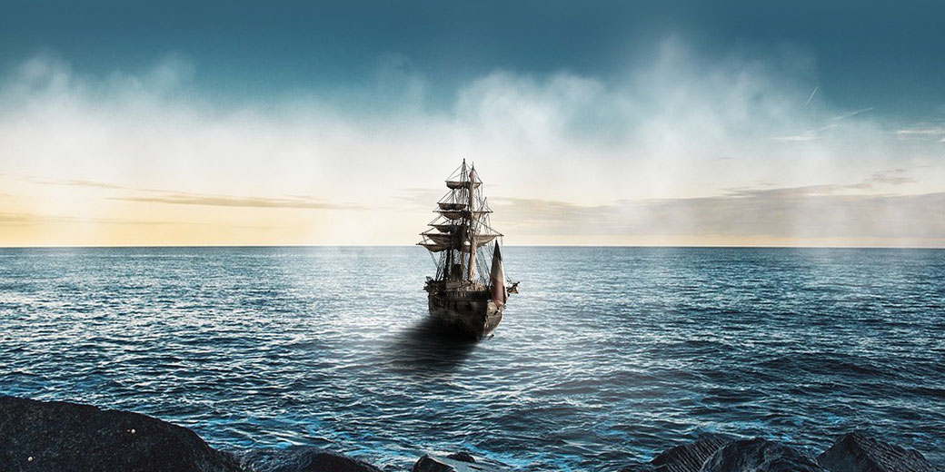 A tall ship sails through calm ocean waters toward the horizon under a partly cloudy sky with golden light.