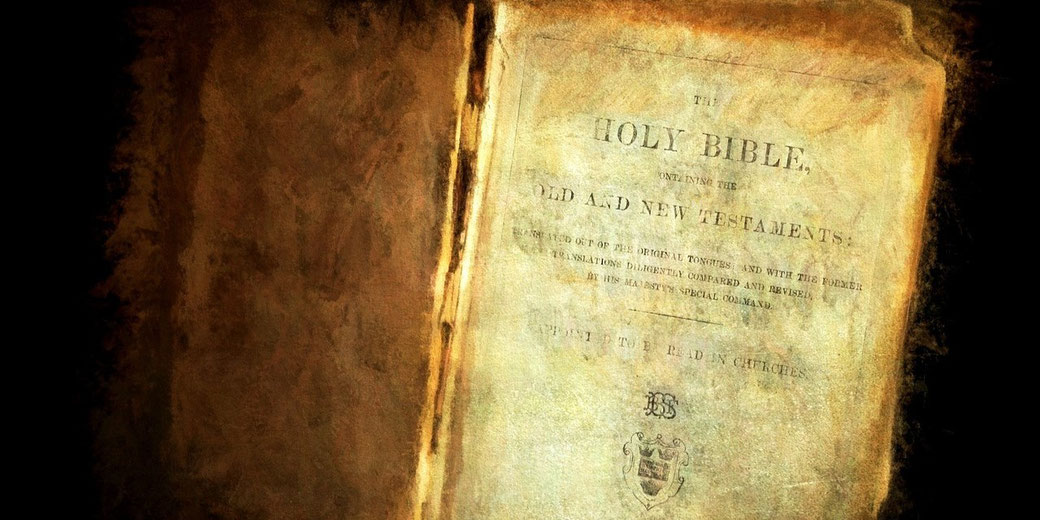 A weathered Holy Bible lies open, showing its aged title page for the Old and New Testaments in faded print.