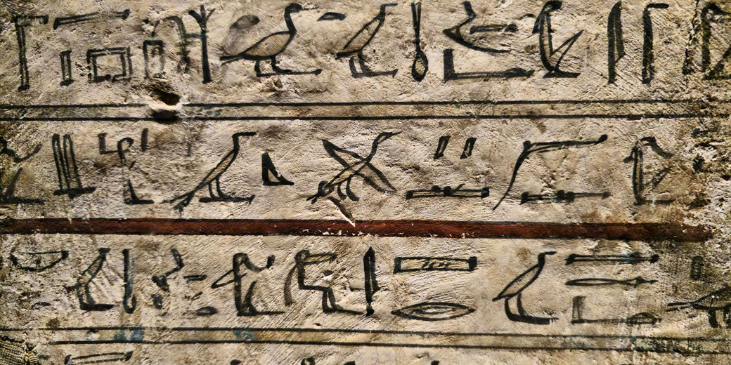 Ancient Egyptian hieroglyphs carved or painted on a stone surface, featuring birds, symbols, and characters arranged in horizontal lines, likely part of a historical inscription or text.