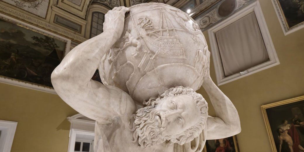 Marble statue of Atlas straining under the celestial sphere, featuring carved constellations and mythological figures, set in an ornate museum room.