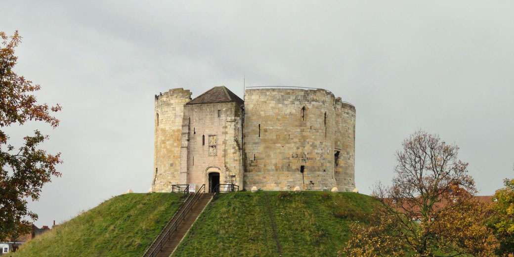 Clifford’s Tower in York, a historic stone keep atop a grassy motte. Once part of York Castle, it played a key role in medieval conflicts and offers panoramic city views today.